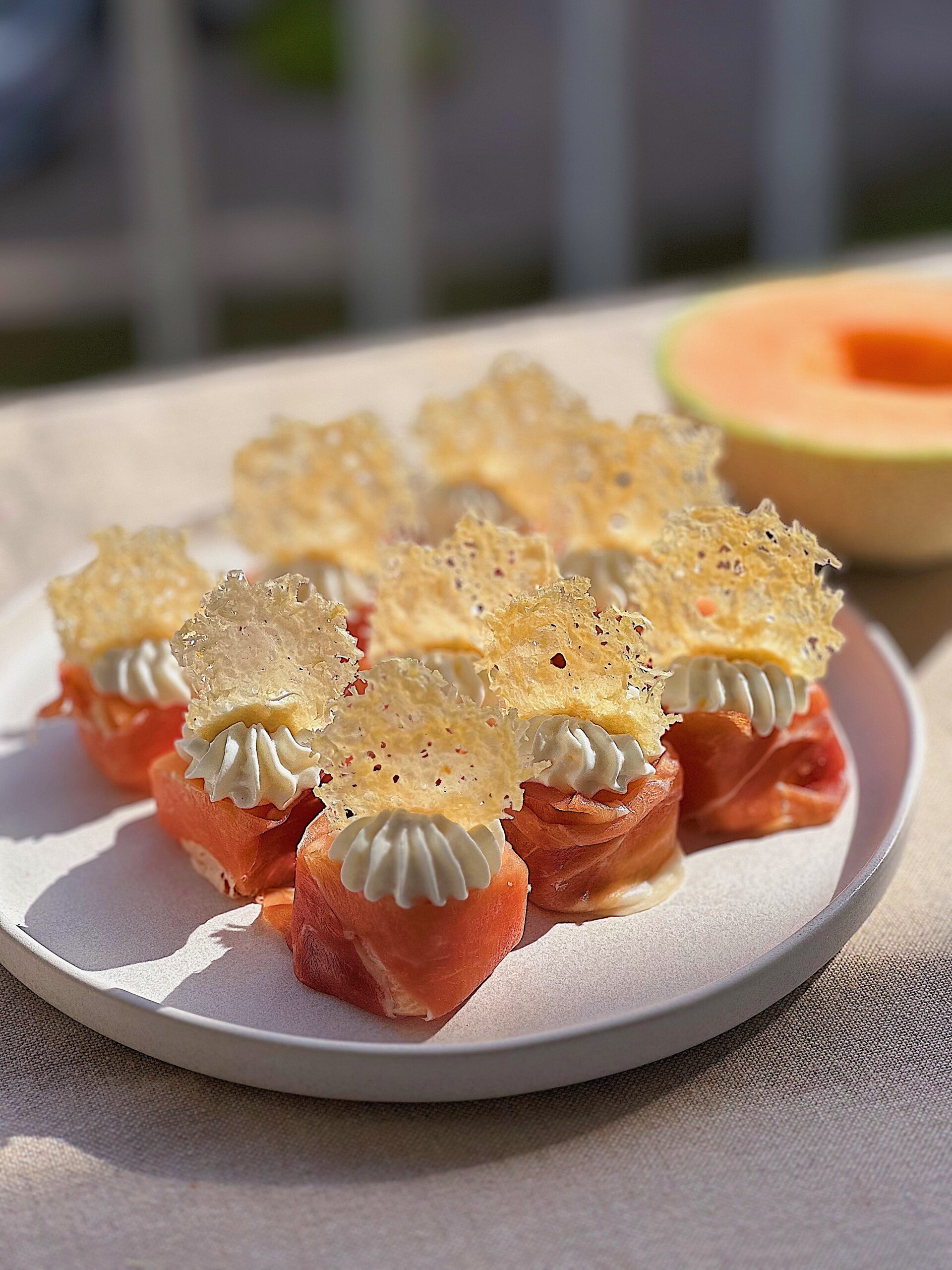 Cantaloupe bidder med serrano, rørt ricotta og parmesanchips